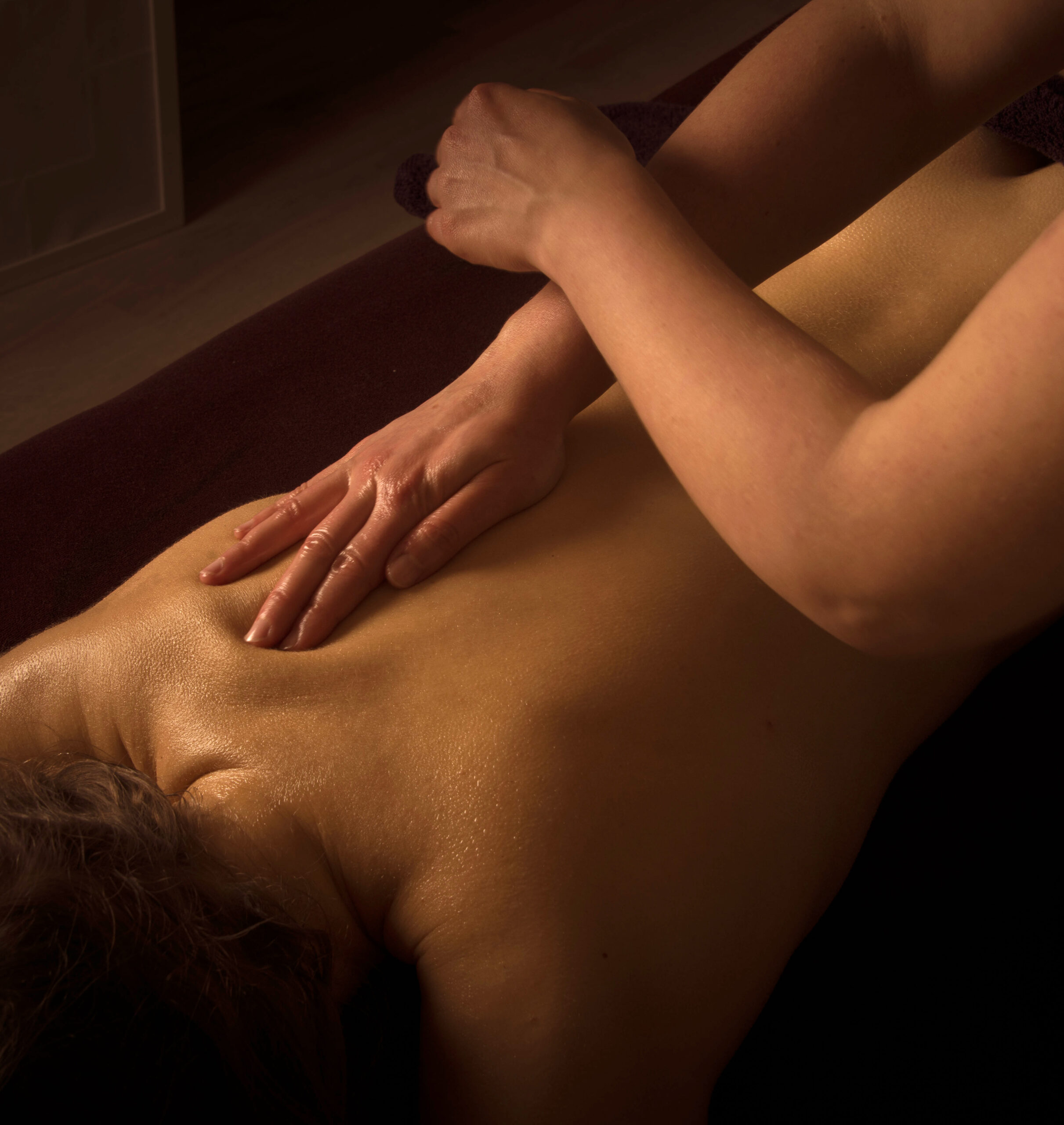person massaging the back of a woman
